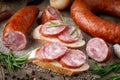 Sandwich with smoked sausage. Dry-cured sausage, bread and spices Royalty Free Stock Photo