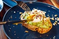 Sandwich, white bread with avocado herbs and spices, with a soft-boiled egg, which is cut with a knife Royalty Free Stock Photo