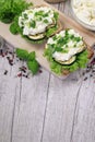 Sandwich with white cream cheese and herbs, chives and basil on a rustic wooden board Sandwich of cheese with herbs. Wooden backgr