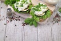 Sandwich with white cream cheese and herbs, chives and basil on a rustic wooden board Sandwich of cheese with herbs. Wooden backgr