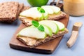 Sandwich with whole grain cracker, green apple slices and peanut butter, on wooden board, horizontal