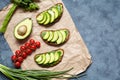 Sandwiches with avocado, guacamole and spinach on parchment on a concrete background. Useful breakfast, lunch. Royalty Free Stock Photo