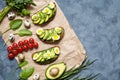 Sandwiches with avocado, spinach, guacamole, arugula and quail eggs on parchment on a concrete background. Spring food Royalty Free Stock Photo