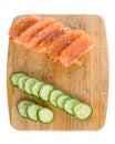 Sandwiches with bread, fresh fish and sliced cucumbers with spices on wooden tray isolated on white background Royalty Free Stock Photo