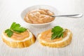 Sandwiches with caviar, parsley, spoon in bowl with salted pollock caviar on table