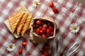 Sandwiches, cherries and chamomile on the tablecloth