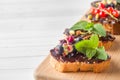 Sandwiches with chocolate paste, pistachio nuts and fresh berries on a wooden serving Board. Copy space Royalty Free Stock Photo