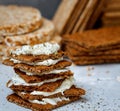 Sandwiches with curd cheese and bread roll for breakfast on a background stacks of various healthy crisp bread