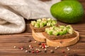 sandwiches with diced avocado, cutted rye bread decorated alligator pear fruit and sprinkle with pepper on wooden