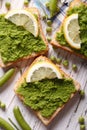 Sandwiches with green peas and lemon closeup. vertical top view Royalty Free Stock Photo