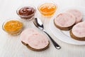 Sandwiches with ham sausage, spoon, bowls with ketchup, squash c