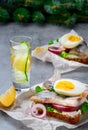 Sandwiches with herring vegetables and eggs, close-up. A glass of gin or vodka on the table. Snack concept, traditional smorrebrod