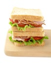 Sandwiches with lettuce,tomato,cold cuts on cutting board on white Royalty Free Stock Photo