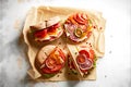 Sandwiches with meat, vegetables and cheese on a light background. Top view