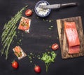 Sandwiches with pink salmon fillet, curd cheese, herbs and cherry tomatoes lined frame a black wooden background backdrop place Royalty Free Stock Photo