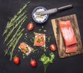 Sandwiches with pink salmon fillet, curd cheese, herbs and cherry tomatoes on wooden rustic background top view close up Royalty Free Stock Photo