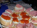Sandwiches with red caviar and slices of salted salmon on the holiday table. Natural food, appetizer. Gorgeous home appetizer