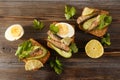 3 sandwiches with rye bread, sprats, fresh cucumber, boiled eggs and parsley, lime