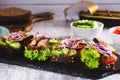 Sandwiches on rye bread with tomatoes, cucumber, sprats and onions on slate Royalty Free Stock Photo