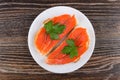 Sandwiches with salted salmon, parsley in plate on wooden table