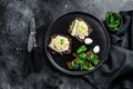 Sandwiches with sardines, egg, cucumber and cream cheese, salad garnish with spinach and dried tomatoes. Black background. Top Royalty Free Stock Photo