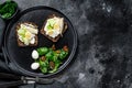 Sandwiches with sardines, egg, cucumber and cream cheese, salad garnish with spinach and dried tomatoes. Black background. Top Royalty Free Stock Photo