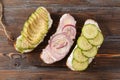 Sandwiches with soft cheese, cucumber and avocado slices, red onion on a wooden background Royalty Free Stock Photo