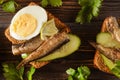 Sandwiches with sprats, fresh cucumber and boiled eggs, closeup