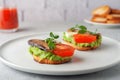 Sandwiches with sprats on toasted slices of bread. Sandwich with smoked sprat - fish, avocado and tomato.