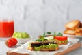 Sandwiches with sprats on toasted slices of bread. Sandwich with smoked sprat - fish, avocado and tomato.