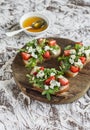 Sandwiches with strawberries, arugula and blue cheese on rustic wooden board on light background. Royalty Free Stock Photo