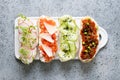 Sandwiches on toast with vegetables, radishes, tomatoes, cucumbers and microgreens on gray. View from above Royalty Free Stock Photo