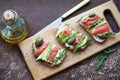 Sandwiches with trout, capers and arugula on wooden board