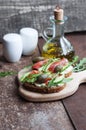 Sandwiches with trout, capers, cucumber and arugula on wooden board