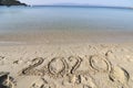 2020 on a sandy background on the beach. New Years concept. Royalty Free Stock Photo