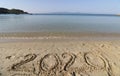 2020 on a sandy background on the beach. New Years concept. Royalty Free Stock Photo