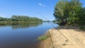 On the sandy bank of the river there is a place for fishing. On stands are installed feeder rods with inertialess reels, and in th