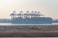 Sandy bank of the Suez Canal, foggy background with container ship.