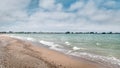 Sandy beach with approaching ocean waves and rocky shoreline Royalty Free Stock Photo