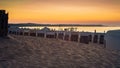 Sandy beach with beach baskets on the Baltic Sea in the glow of the setting sun