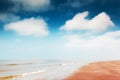 Sandy beach and blue sky with white clouds Royalty Free Stock Photo