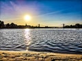 Sandy beach and blue water at  Sundown over the riverside of the river Rhein in Cologne with sky, clouds and bridge Royalty Free Stock Photo