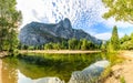 Sandy beach and clean still water of the Merced River reflect Sentinel Rock on a sunny day in Yosemite Royalty Free Stock Photo