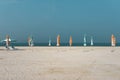 Sandy beach with closed umbrellas Royalty Free Stock Photo