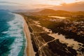 Sandy beach with dunes, ocean and town with sunset in Campeche, Florianopolis