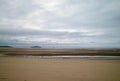 A sandy beach exposed by a receding tide.