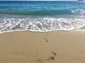 Sandy beach, footprints in the sea Royalty Free Stock Photo