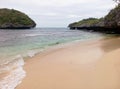 Sandy beach and hanging rocks on the Old Scout Island of 100 Islands (Hundred Islands National Park) in the northern Philippines. Royalty Free Stock Photo