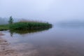 Sandy beach after heavy rain, white fog on the lake, fuzzy contours