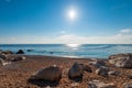 Sandy beach, large stones, blue sea and bright sun - beautiful s